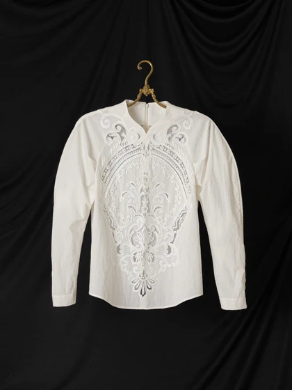 Embroidered lace blouse on a brass hanger