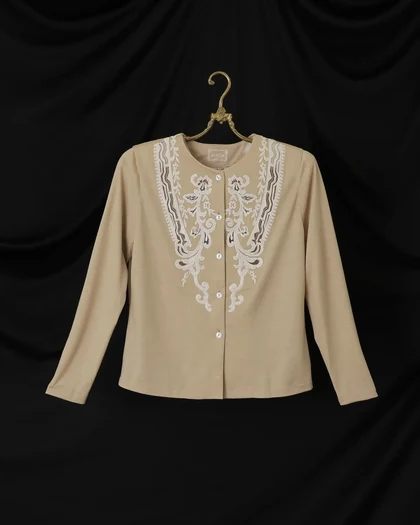 Beige jacket with white lace appliqué on a brass hanger