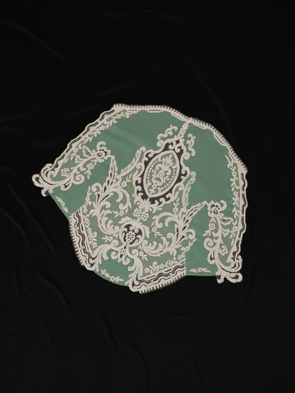 Antique lace panel laid on dark drapery