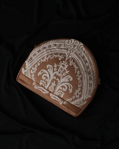 Rose-toned lace piece on dark drapery