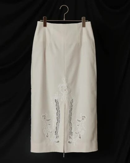 Ivory skirt with cutwork embroidery on a wooden hanger